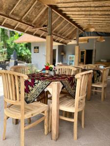 una mesa de madera con sillas y un mantel. en Manuk Dewata Villa, en Sidemen