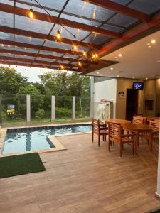 a patio with a table and chairs and a pool at POUSADA ALTER PARA TODOS in Alter do Chao