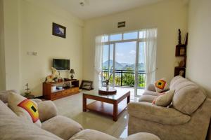 a living room with two couches and a television at Amandara Hills Kandy in Kandy