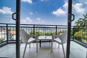 a balcony with a table and chairs and a view at Amandara Hills Kandy in Kandy