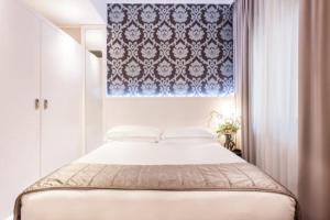 فندق فيلا روزا ريفيرا  في ريميني: غرفة نوم بسرير وستارة زرقاء وبيضاء