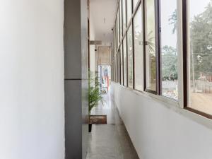 un corridoio con finestre e una pianta in vaso di Collection O Yashaswi Comforts a Mysore