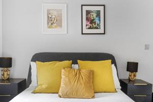 sypialnia z łóżkiem z żółtymi poduszkami i 2 lampami w obiekcie Luxury 1 Bedroom Lace Market Apartment w Nottingham