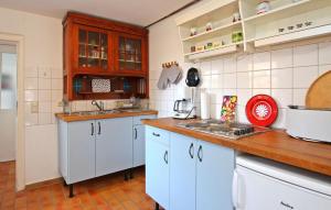 een keuken met witte kasten en een houten aanrecht bij Amazing Apartment In Rbel-mritz With Kitchen in Röbel