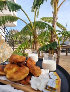 クサミルにあるKel Roomsのテーブルの上には牛乳とパンが添えられた食べ物の皿がある