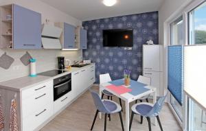 a kitchen with a table and blue chairs in a kitchen at Beautiful Apartment In Graal-mritz ostseehe With Kitchen in Müritz