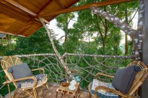 a group of chairs and a table on a patio at PANCHAVADI FARM STAY in Thekkady