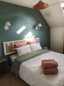 1 dormitorio con 1 cama grande y paredes rosas y verdes en Gîte Les Caves aux Fièvres - Maison avec jardin près de Chinon, en Beaumont-en-Véron