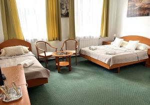 布达佩斯Broadway City Guesthouse的一间有两张床、一张桌子和几把椅子的酒店房间