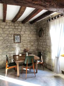 comedor con mesa de madera y sillas en Gîte Les Caves aux Fièvres - Maison avec jardin près de Chinon, en Beaumont-en-Véron