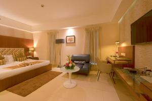 a hotel room with a bed and a desk at Celesta - Kolkata in Kolkata