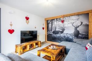 a living room with two couches and a tv at Gite de la voie verte gitesdes2vallees in Cornimont