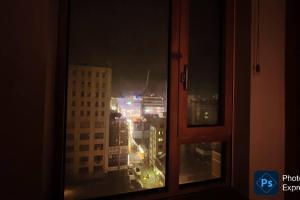 einen Blick auf die Stadt in der Nacht von einem Fenster aus in der Unterkunft Party Room, 1min to Suwon Rodeo Street in Suwon