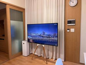 einen Flachbild-TV auf einem Stand in einem Zimmer in der Unterkunft Party Room, 1min to Suwon Rodeo Street in Suwon