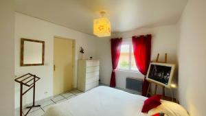 a bedroom with a bed and a window with red curtains at « La Cigale » in Peyruis