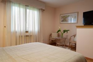 een slaapkamer met een bed, een tv en een raam bij Motel Bambú in Lugo
