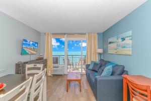 a living room with a couch and a table with a view of the ocean at Boardwalk 1139 & 1140 in Myrtle Beach