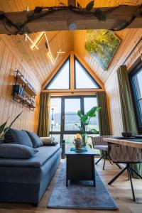 a living room with a couch and a large window at Taunus Tinyhouse in Weilrod