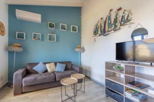 uma sala de estar com um sofá e uma televisão em Azura Prugna - Maison avec piscine partagée em Grosseto-Prugna