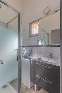uma casa de banho com um lavatório e um espelho em Azura Prugna - Maison avec piscine partagée em Grosseto-Prugna