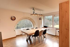 uma sala de jantar com uma mesa de madeira e cadeiras em La Perle de Xonrupt - Appt vue montagne em Xonrupt-Longemer