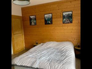 um quarto com uma cama com fotografias na parede em La Perle de Xonrupt - Appt vue montagne em Xonrupt-Longemer