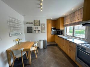 een keuken met een houten tafel en stoelen en een aanrecht bij Villa Dageraad in De Panne