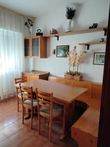 a dining room with a wooden table and chairs at Appartamento Alla Vigna in Levico Terme