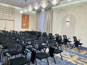 KHAN ORDASY في Zhezqazghan: غرفة بها صفوف من الكراسي في غرفة