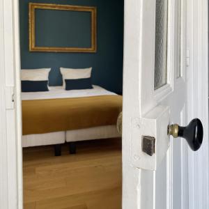 a bedroom with a bed with blue walls and a door at Suite Lavarande by La Boîte En Plus in Senlis