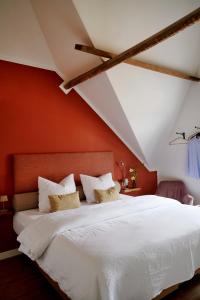 a bedroom with a white bed with red walls at La Dominotte Arcen in Arcen