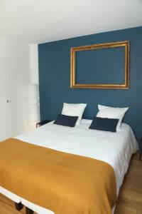 - une chambre avec un grand lit et un mur bleu dans l'établissement Suite Lavarande by La Boîte En Plus, à Senlis
