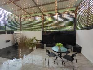 een kamer met een tafel en stoelen en een aantal ramen bij CASA homestay 軒名宿 in Miri