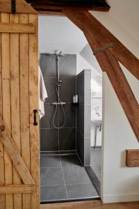 a bathroom with a shower with a glass door at La Dominotte Arcen in Arcen