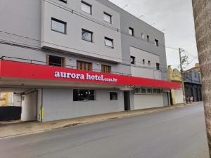 Un edificio con un cartel rojo al costado. en Aurora Hotel, en Ribeirão Preto
