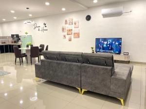 a living room with a couch and a dining room at Cloud Nine Homestay in Taiping