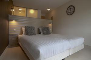 a bedroom with a large bed with a clock on the wall at Boshotel Overberg in Overberg