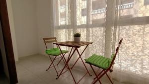 una mesa y dos sillas frente a una ventana en alquilaencanarias El Medano, El Cabezo, next to the beach !!!, en El Médano