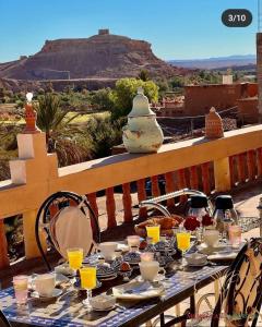 einen Tisch mit Gläsern Orangensaft und Bergblick in der Unterkunft L'oasis Du Bonheur in Aït-Ben-Haddou