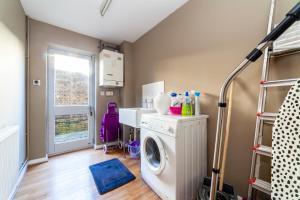 a laundry room with a washing machine and a washer at Wonderful 5 BDR Flat wParking, Maida Vale in London