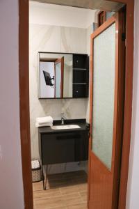 uma casa de banho com um lavatório e um espelho em Albora Guest House em Fier