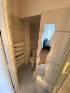 een kleine badkamer met een toilet in een kamer bij Studio Proche Paris in Chaville