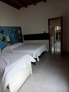 a bedroom with two beds and a hallway at Casa amplia y bien ubicada in Artigas