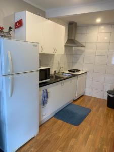 a kitchen with white cabinets and a refrigerator at Sunny holiday home Wellington in Wellington