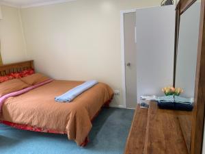 una camera con letto e struttura in legno di Sunny holiday home Wellington a Wellington