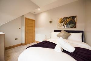 a bedroom with a large white bed with white pillows at Elm House in Reading
