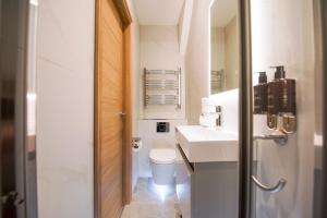 a white bathroom with a toilet and a sink at Elm House in Reading