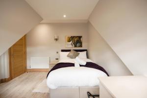 a bedroom with a white bed in a attic at Elm House in Reading