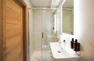 La salle de bains est pourvue d'une douche et d'un lavabo blanc. dans l'établissement Elm House, à Reading