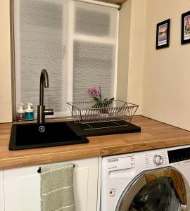 a kitchen with a sink and a washing machine at Chapter Cottage, Cheddleton Nr Alton Towers, Peak District, Foxfield Barns in Cheddleton